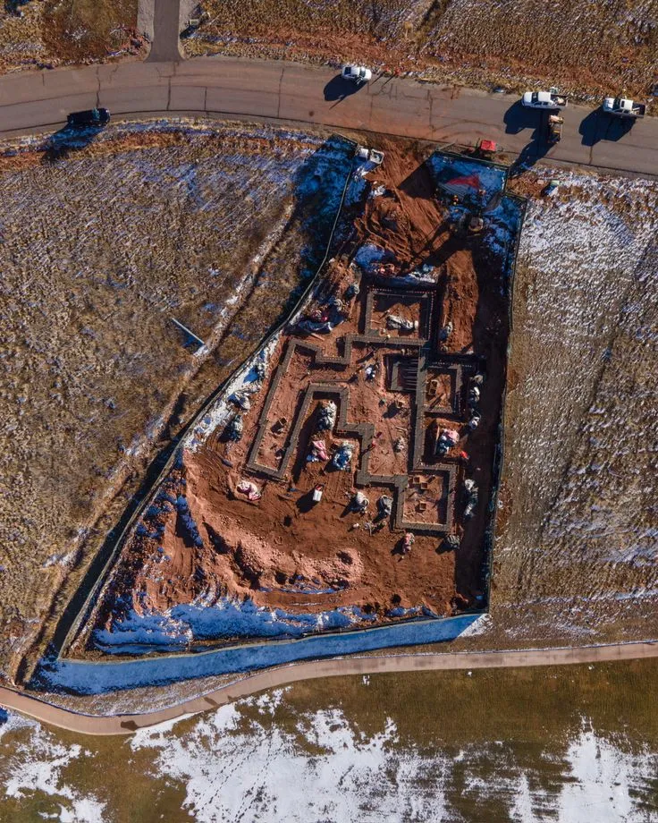 Extensive land grading and concrete retaining walls required for building a house on sloping topography
